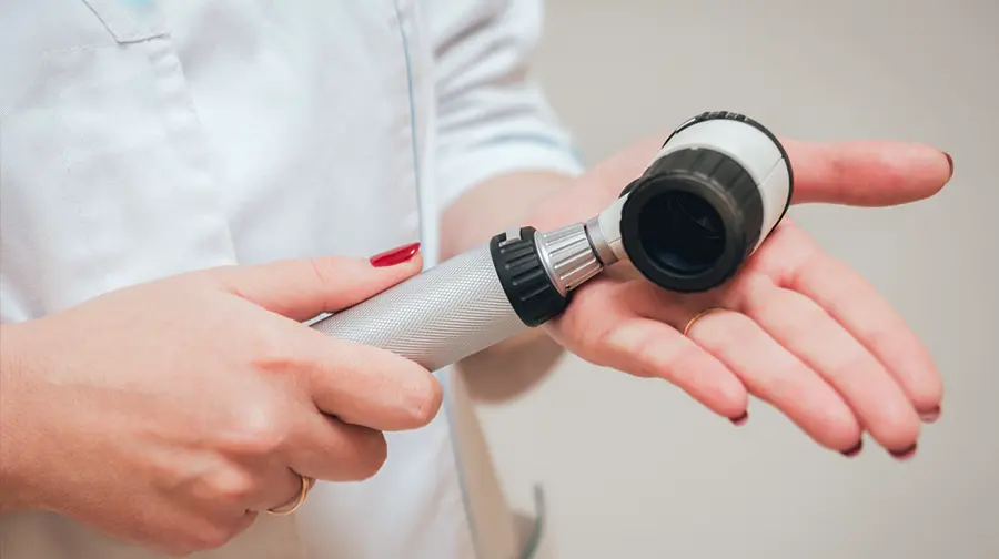 Ärztin hält ein Dermatoskop zur Hautuntersuchung Ärztin hält ein Dermatoskop zur Hautuntersuchung
